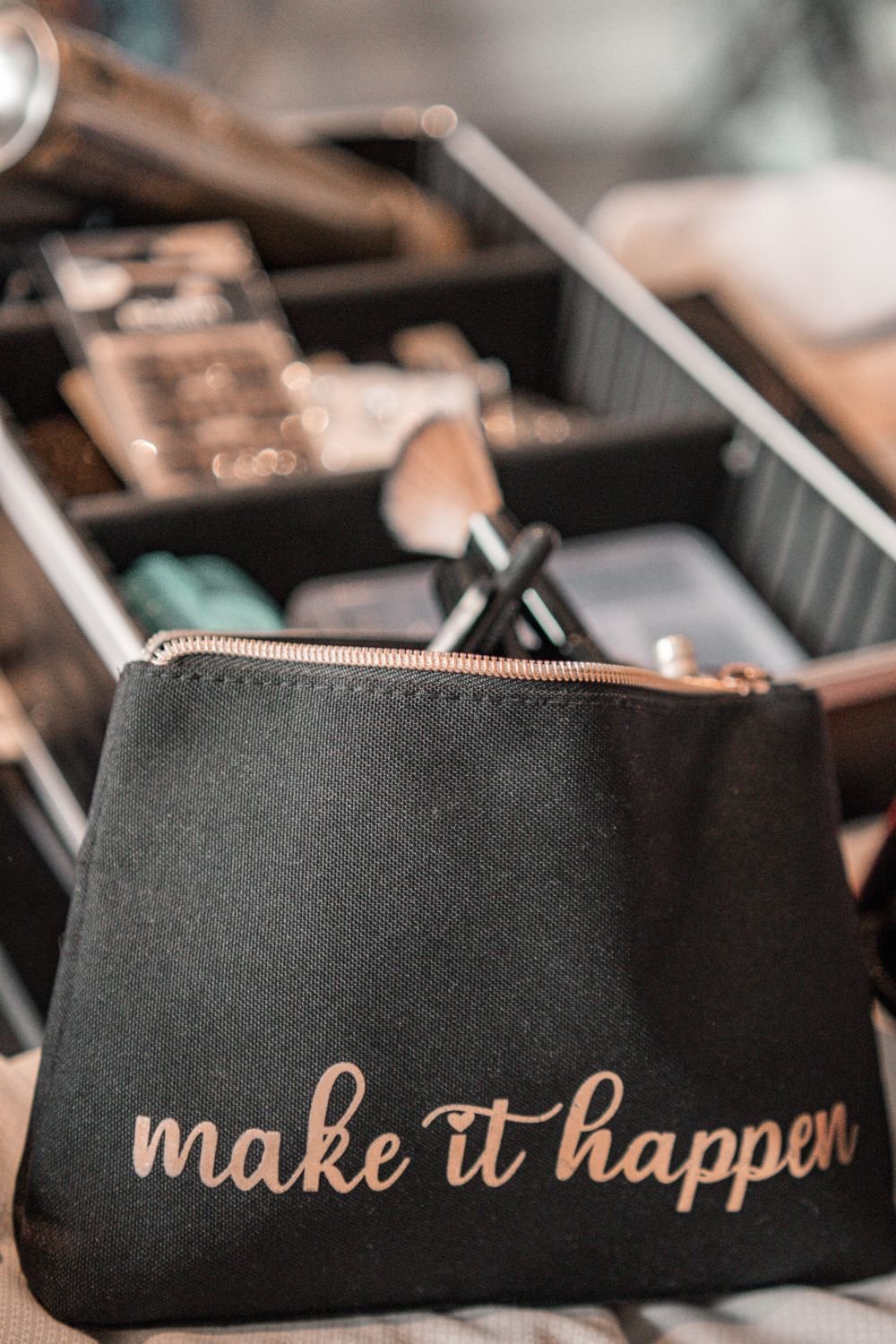 Schwarze Tasche mit rosafarbener Schrift, die sagt 'make it happen'. Im Hintergrund ein Werkzeugkasten mit verschiedenen Werkzeugen.