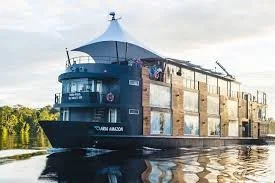 A large, modern river cruise ship on a calm river during the day.
