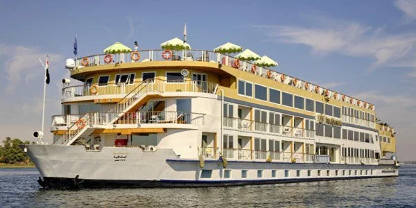 A large multi-deck cruise ship sailing on a river or lake during daytime.