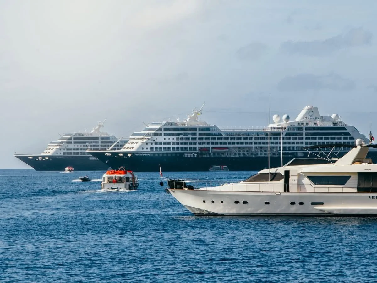 Several luxury yachts and boats on the ocean with the sky in the background.