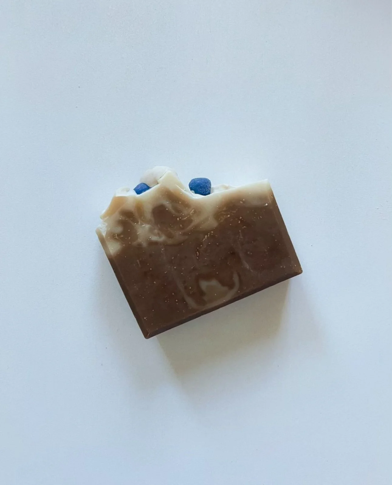 Piece of soap with swirls of white and blue, placed on a white surface