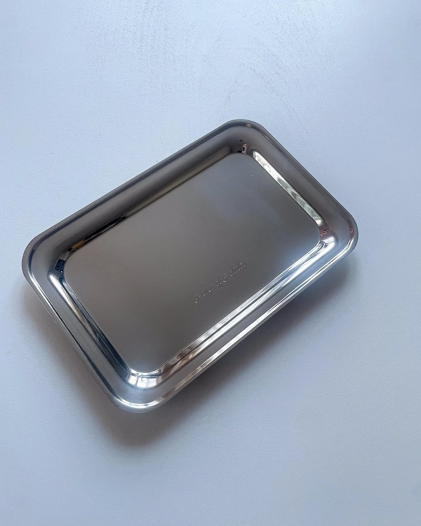 A rectangular stainless steel container with rounded edges, placed on a white surface.