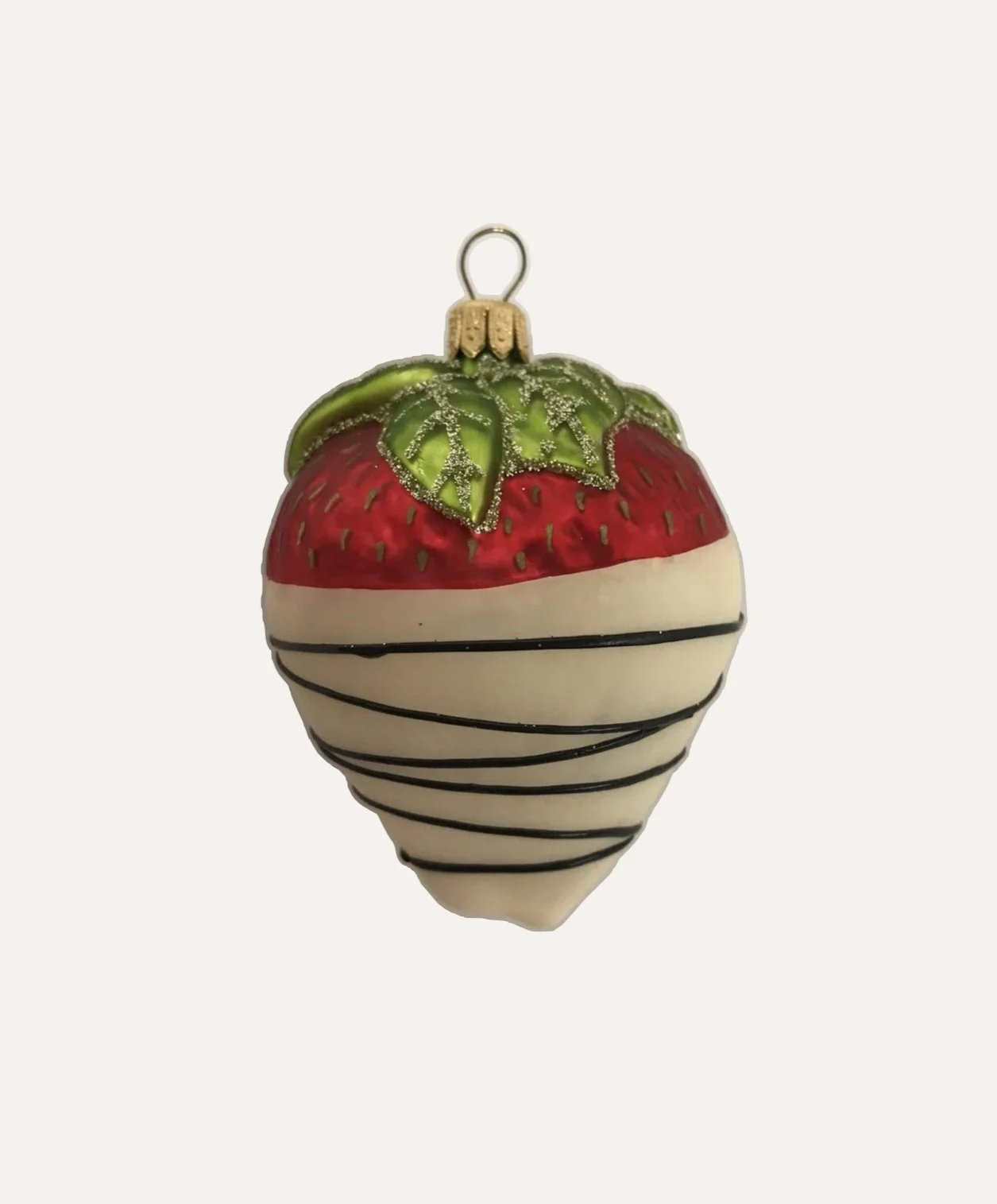 Decorative Christmas ornament shaped like a strawberry, white with black stripes, topped with green leaves and a gold cap.
