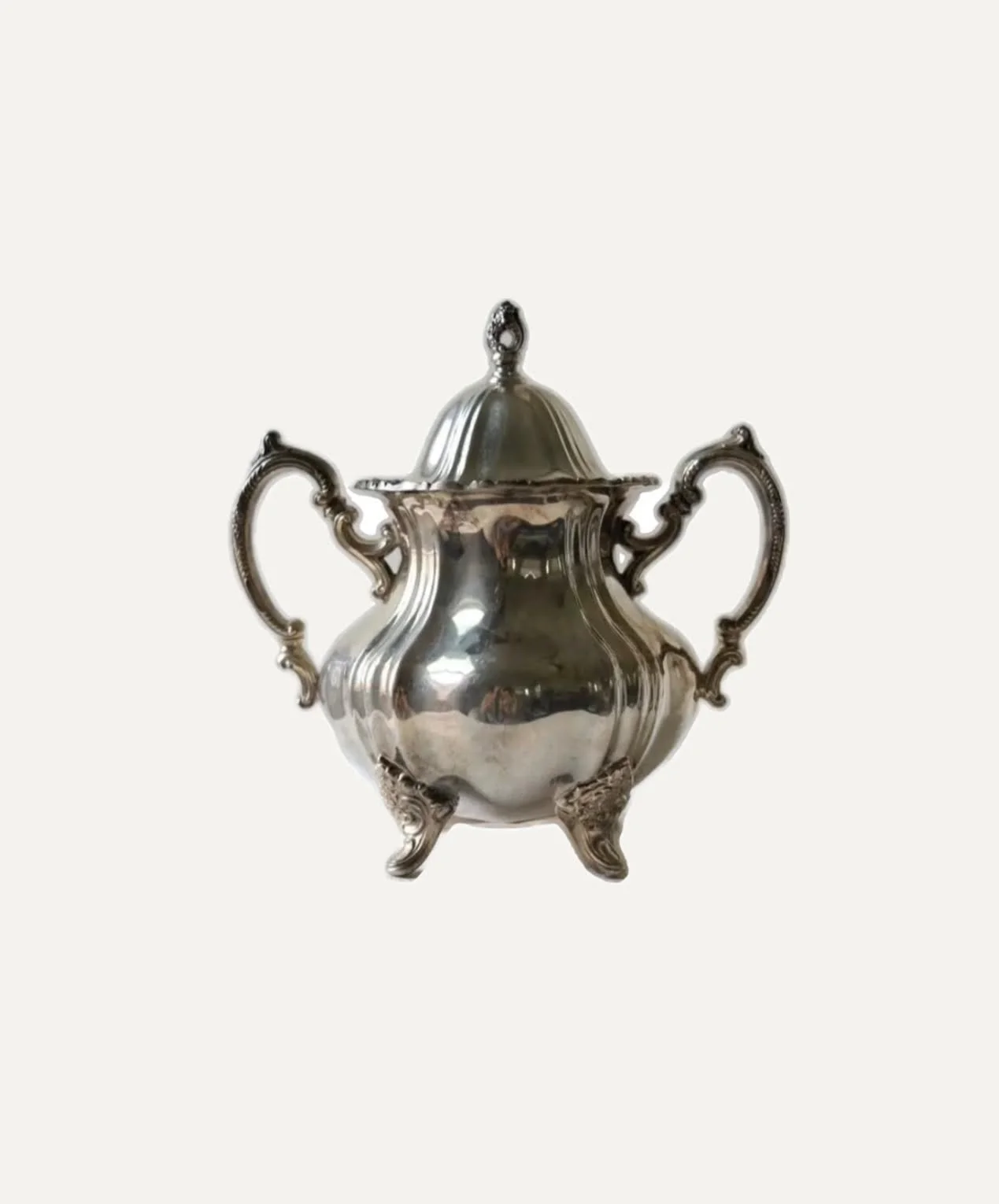 Silver antique urn with decorative handles and feet, featuring a lid with a finial on top.