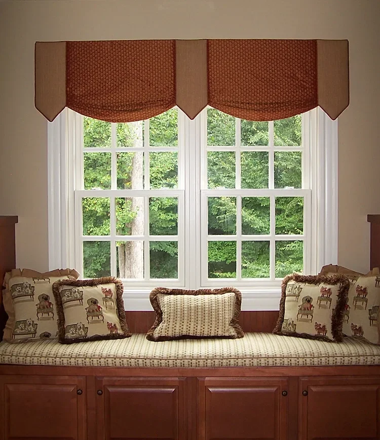 A window seat with plush cushions and a view of green trees outside.