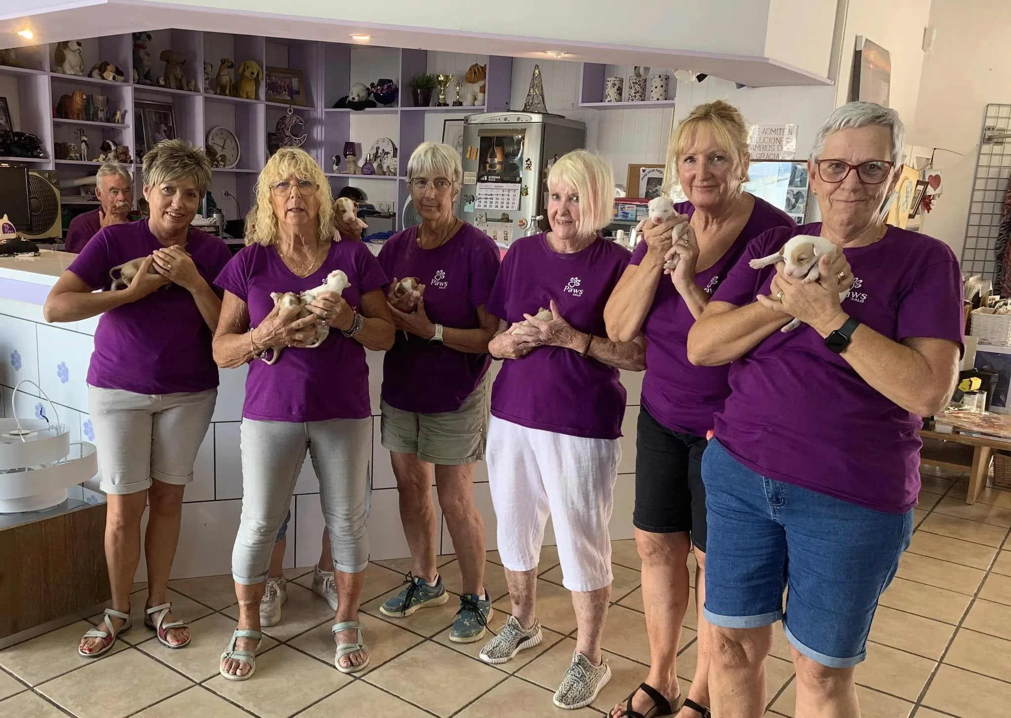 Volunteers at the Paws Xaló shop. holding newly-rescued puppies