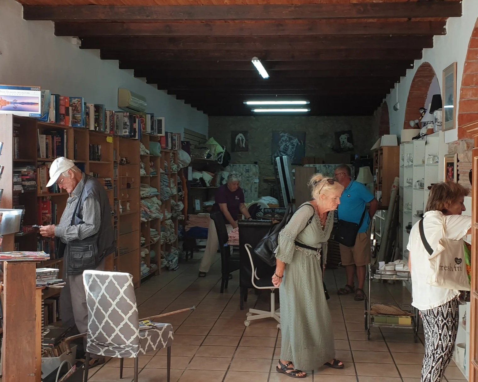Interior of the Paws Xaló Charity Shop with people browsing