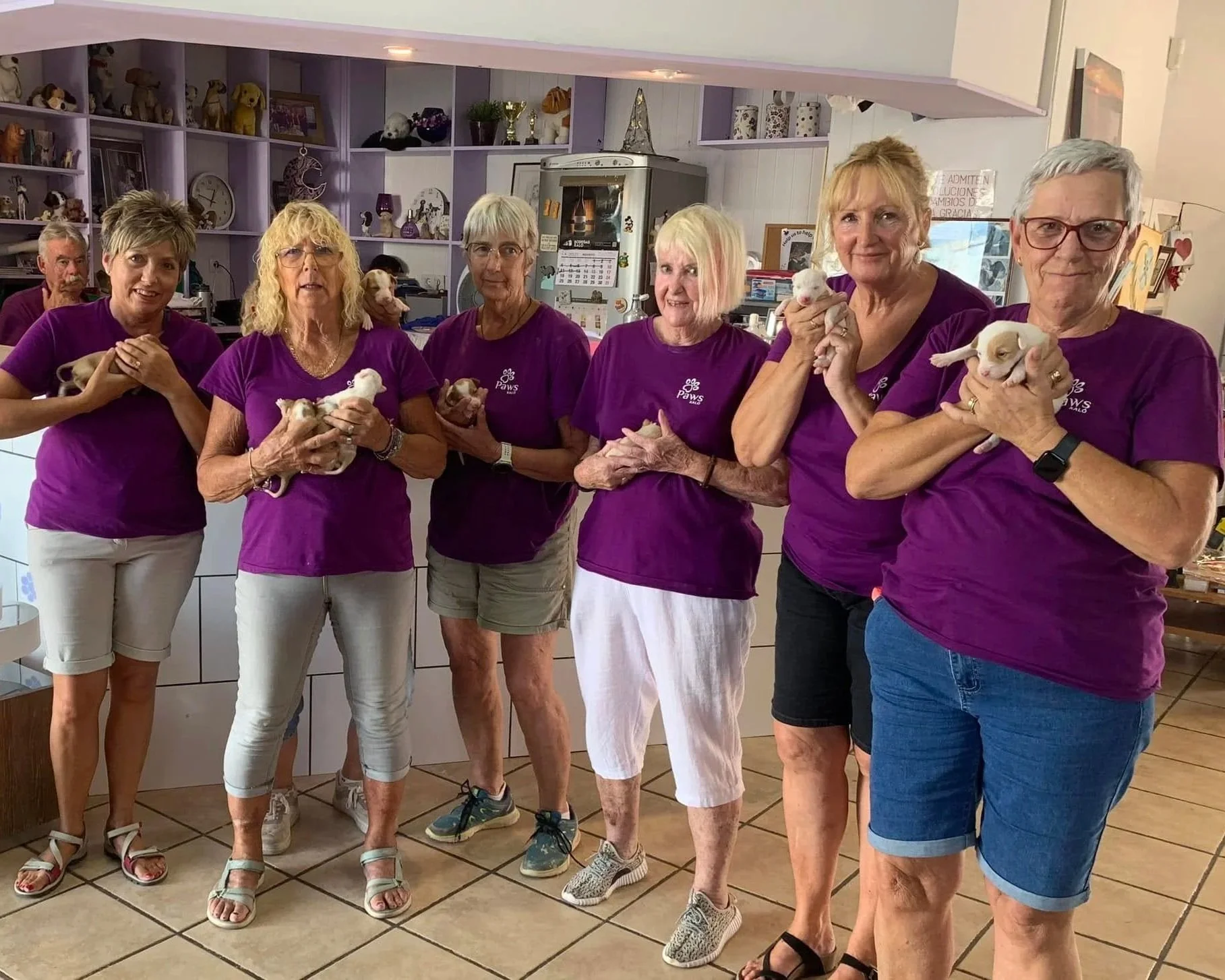 Volunteers at the Paws Xaló shop. holding newly-rescued puppies