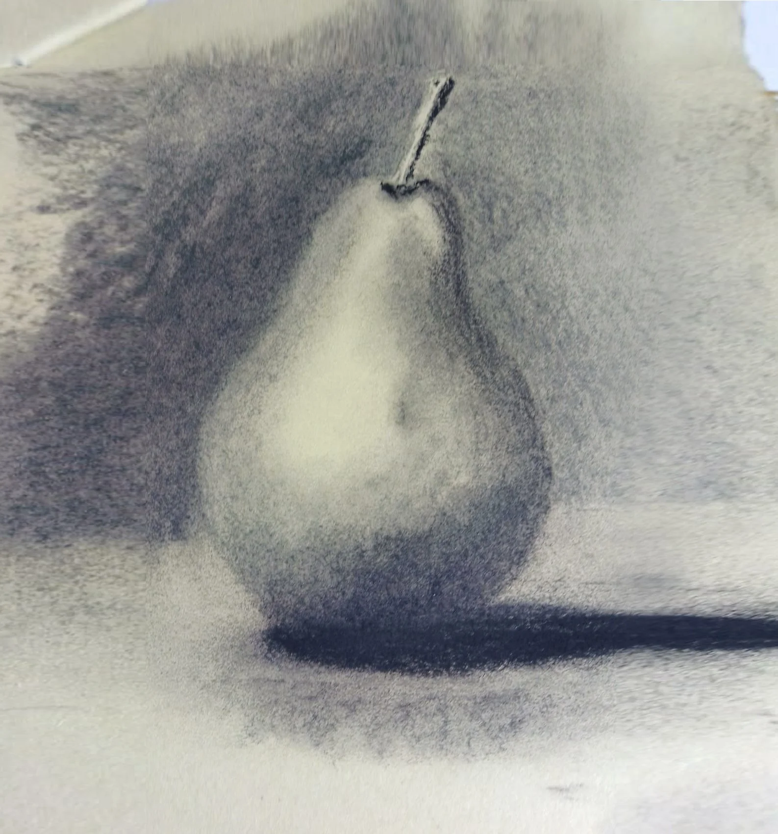 A pear with a shadow on a surface.