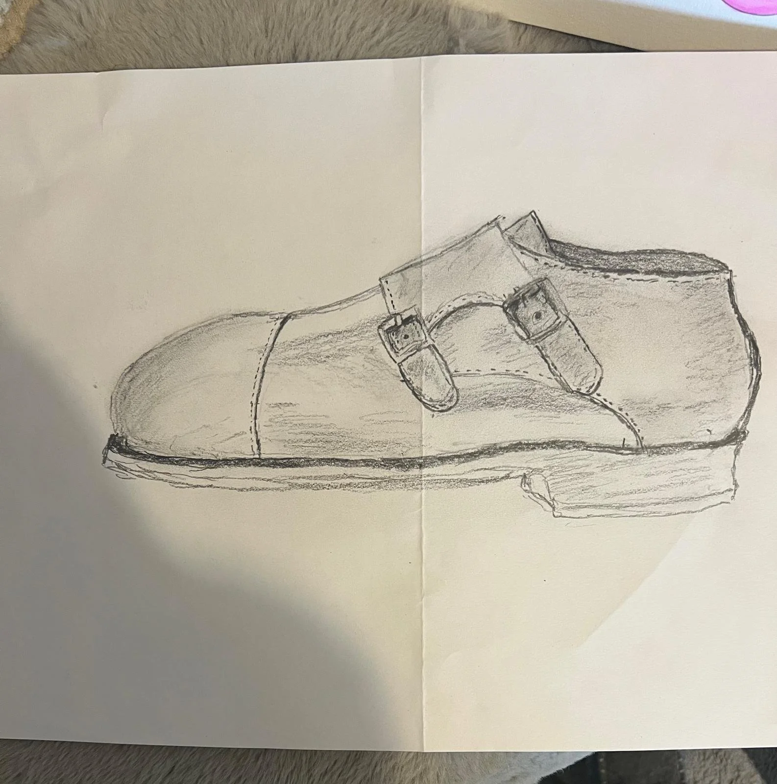 A pencil sketch of a closed dress shoe with two buckles, shown in side view.