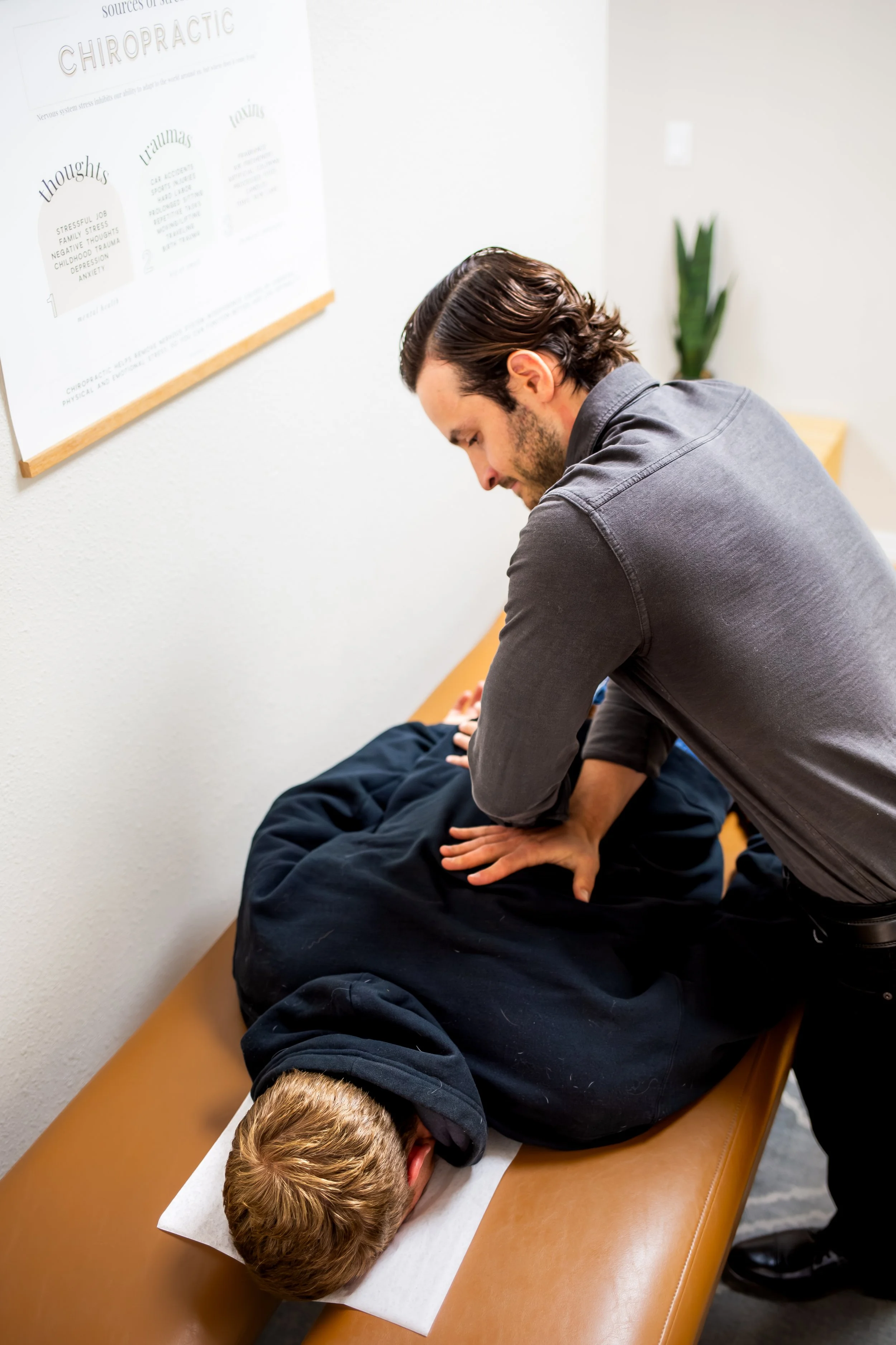 A man receiving chiropractic care from a chiropractor in an office setting.