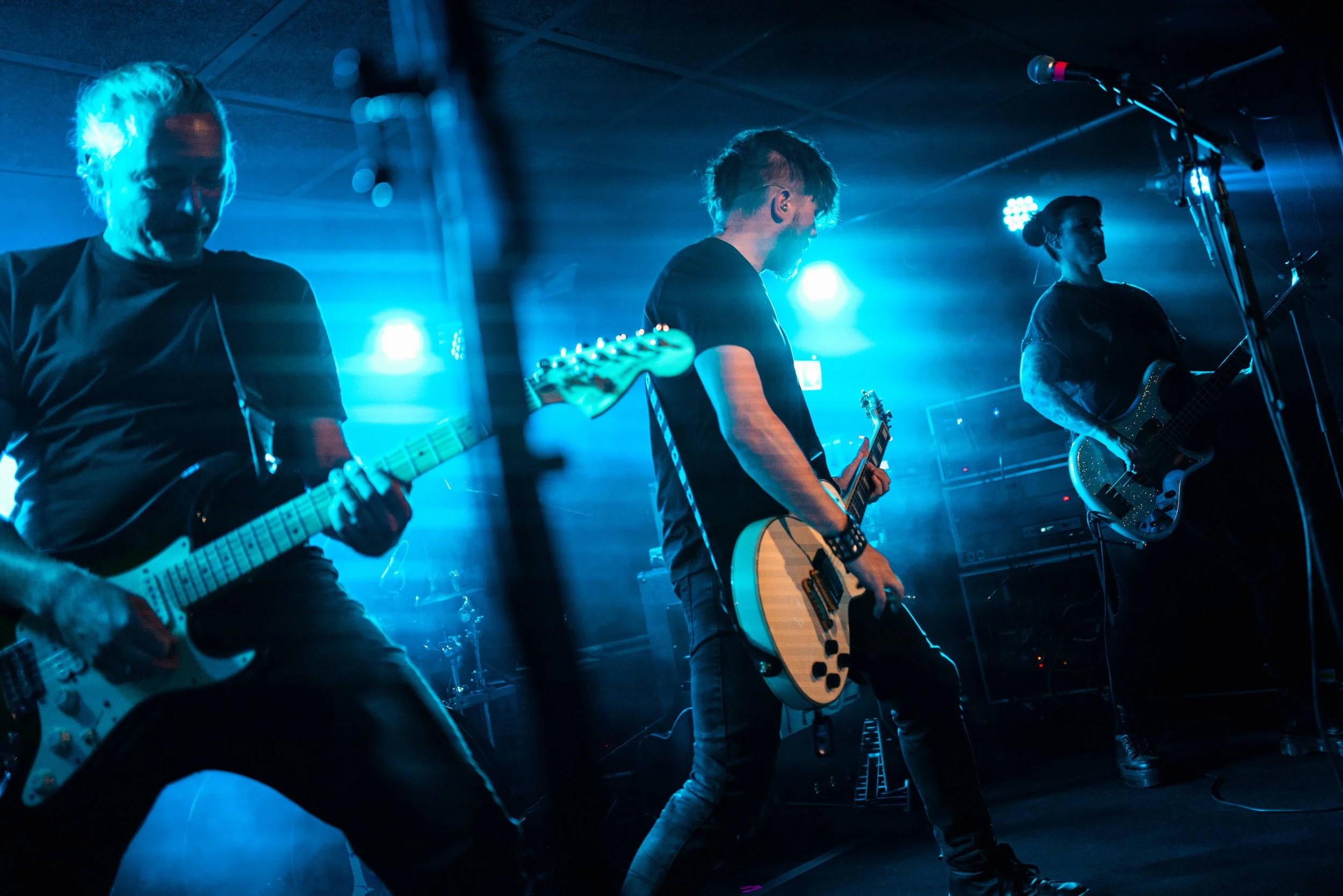 Stefan, Manuel und Diana (v.l.n.r.) von Endzeitparty live on stage in blauem Bühnenlicht