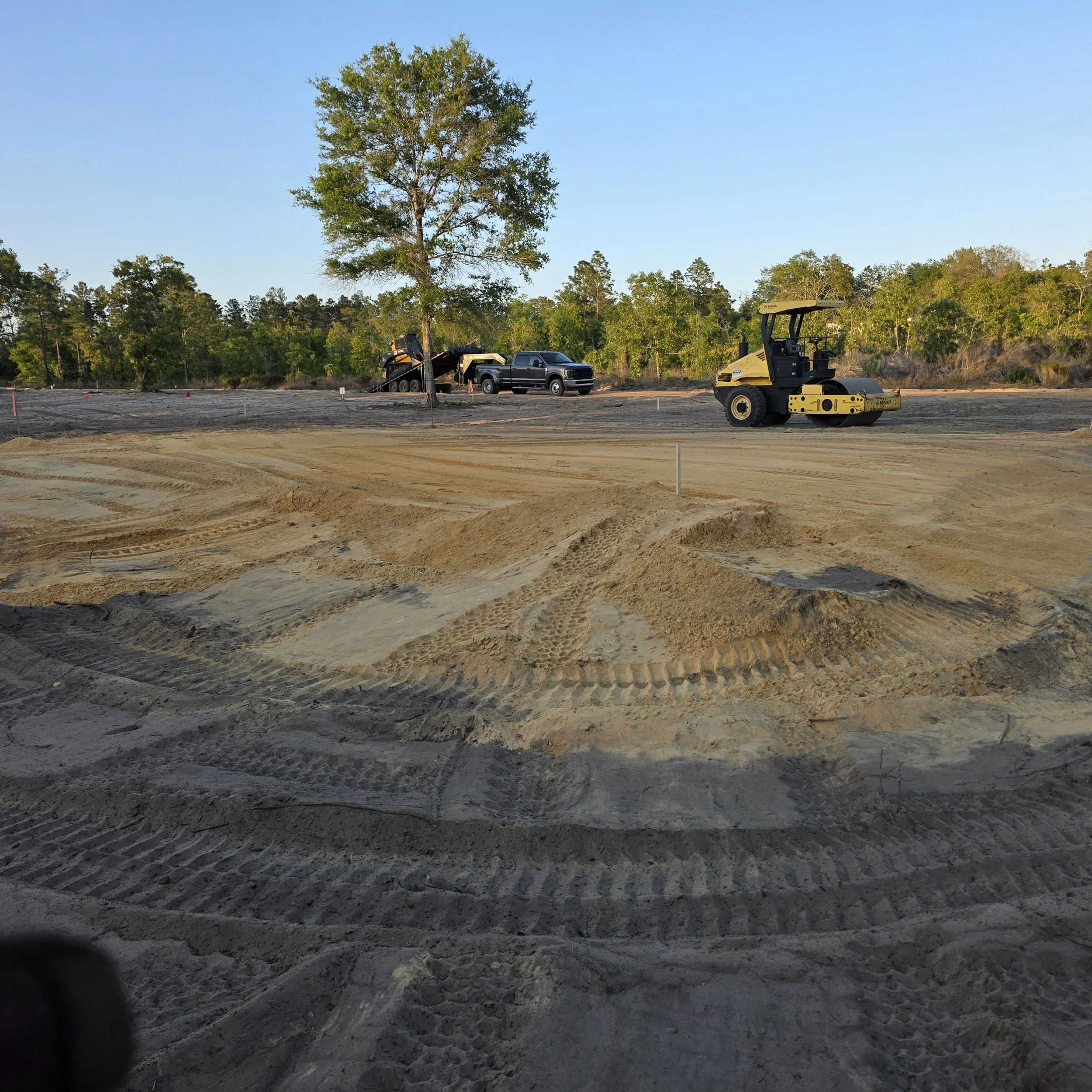 Clean fill dirt being compacted with a 10,000-pound vibrating roller during Hawthorne house-pad construction