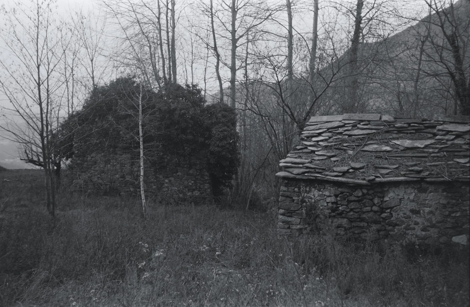 two stone huts in black and white