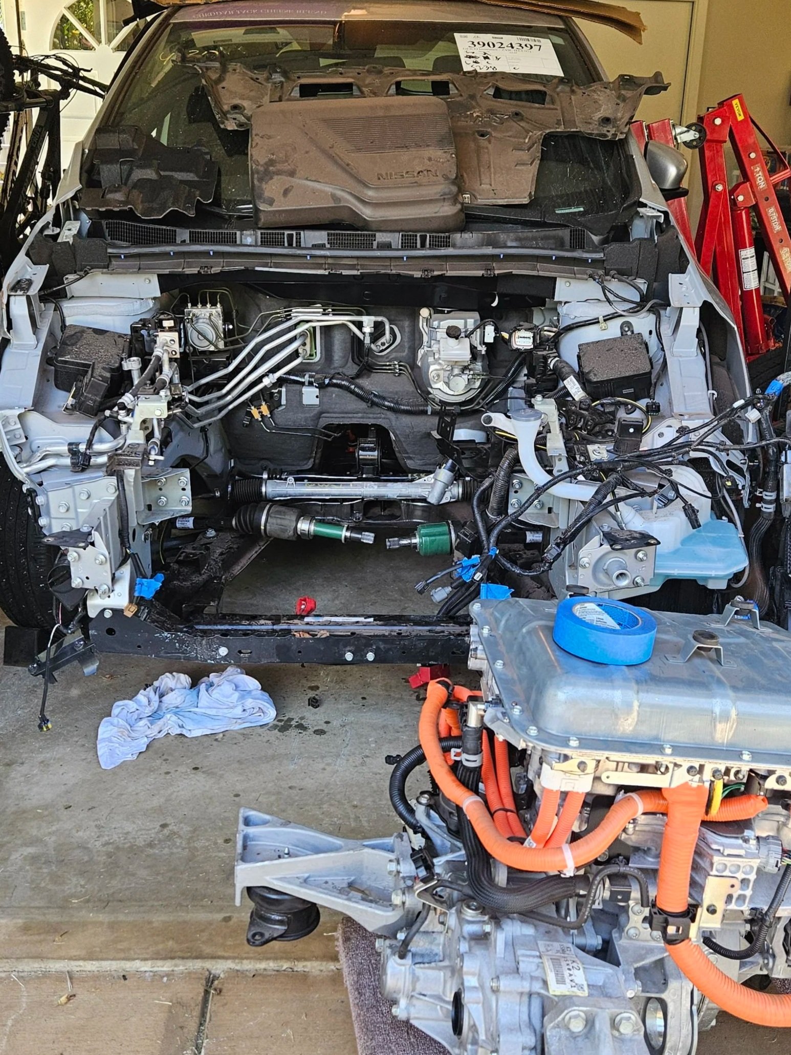 vehicle with entire middle front removed behind motor with bright orange cables