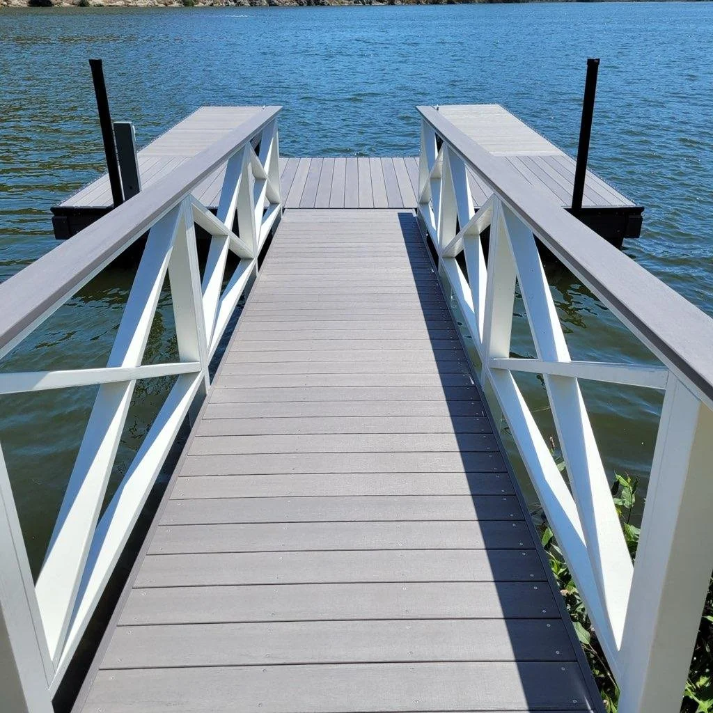 A small dock with white railings extending over a body of water.