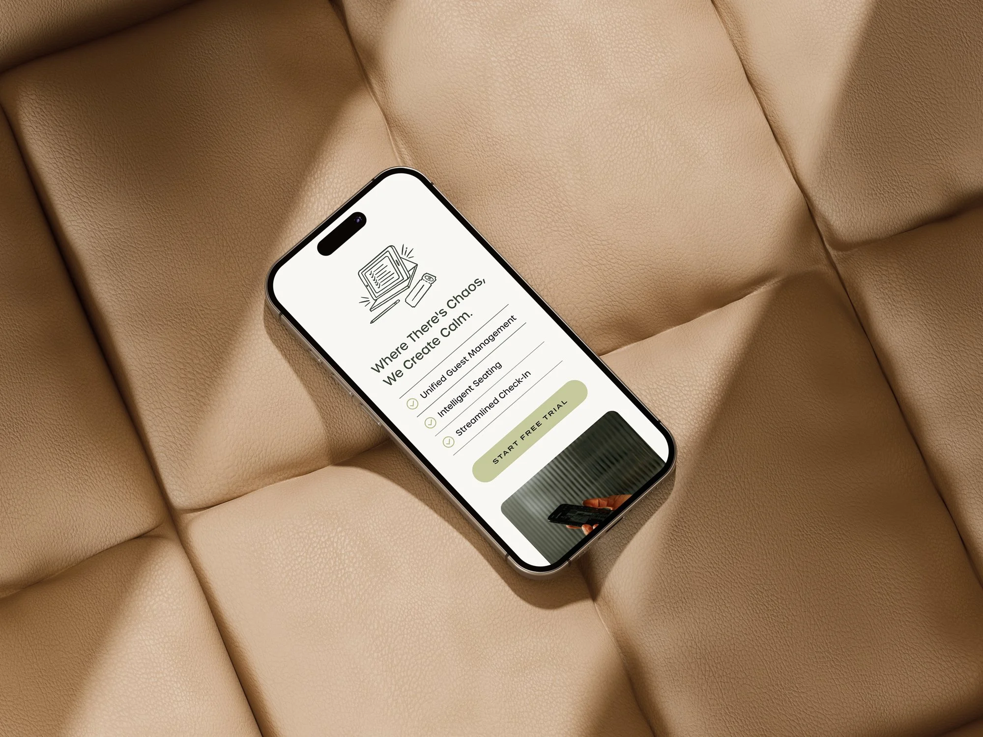 Smartphone on a tan leather couch displaying an app interface with text about creating calm and a start free trial button.