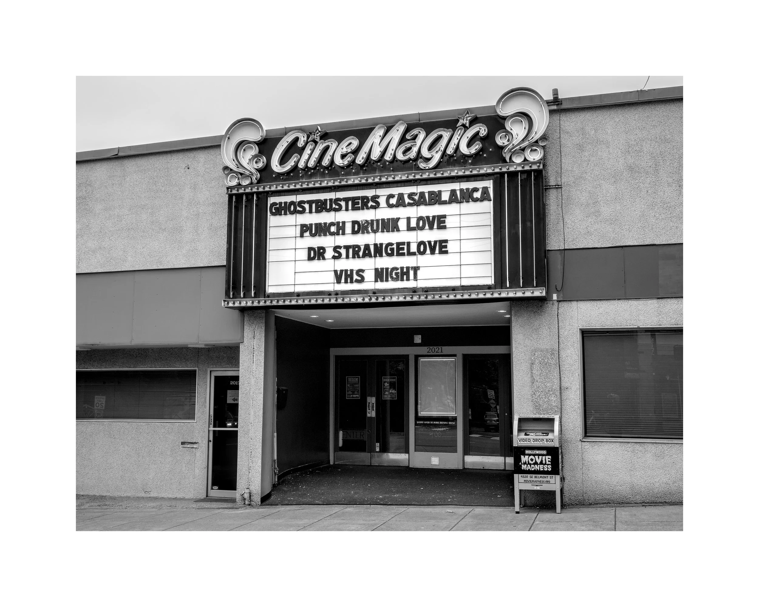 Marquee of Cinema Magic theater displaying upcoming movie titles in black and white.