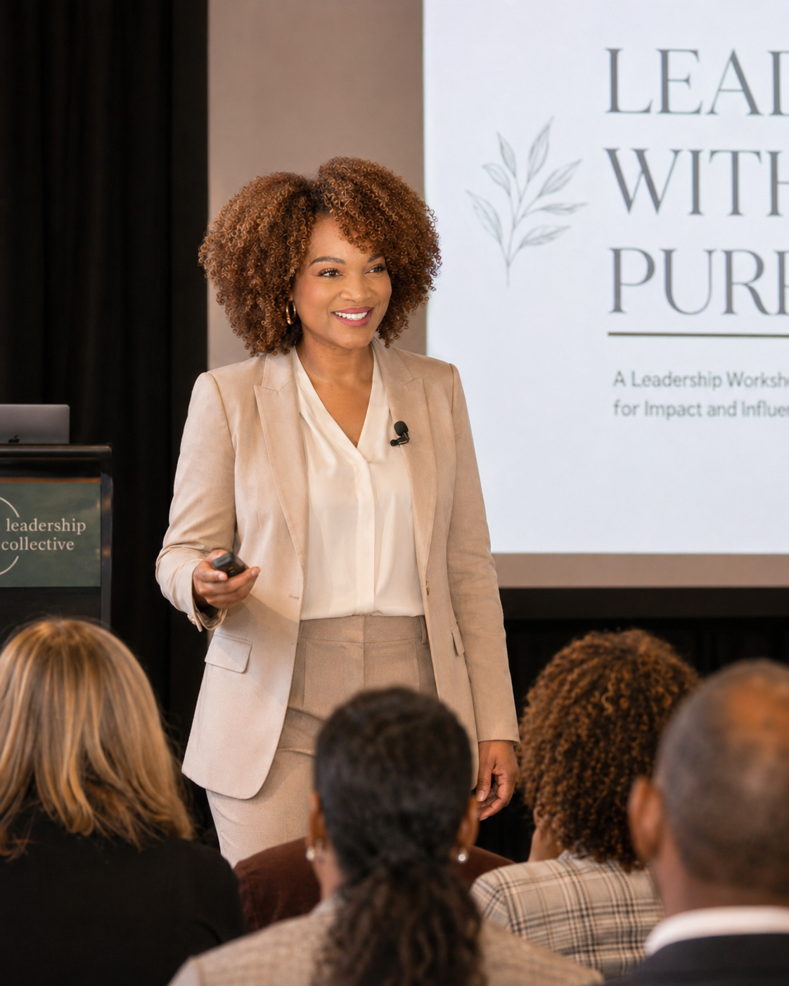 Keisha Gaddis in a beige suit giving a presentation in front of an audience, with a slide that reads 'Lead with Purpose' in the background.