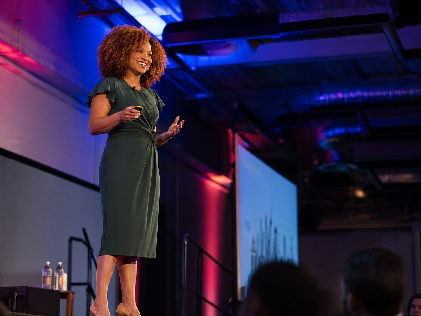Keisha Gaddis standing on a stage speaking at a conference.