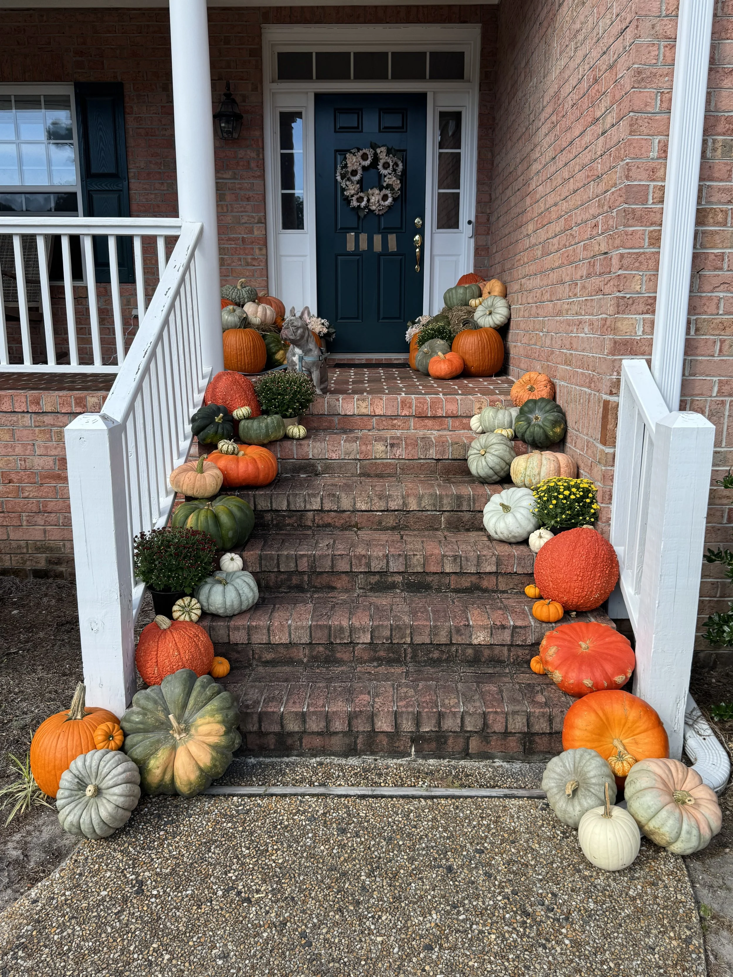 Fall pumpkin display on a front porch of a beautiful home