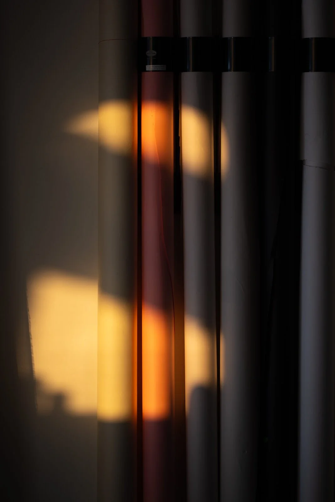 Sunlight shining through a window creates colorful reflections on a wall, with bright yellow, orange, and red hues.