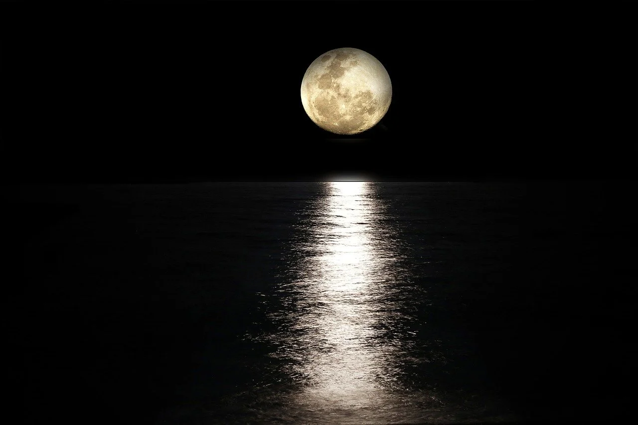Full moon over water with reflections at night.