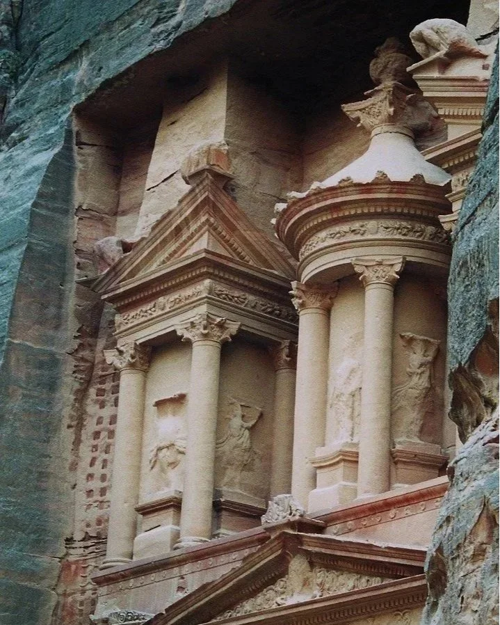 Ancient rock carving of a classical building facade with columns, pediments, and decorative details.