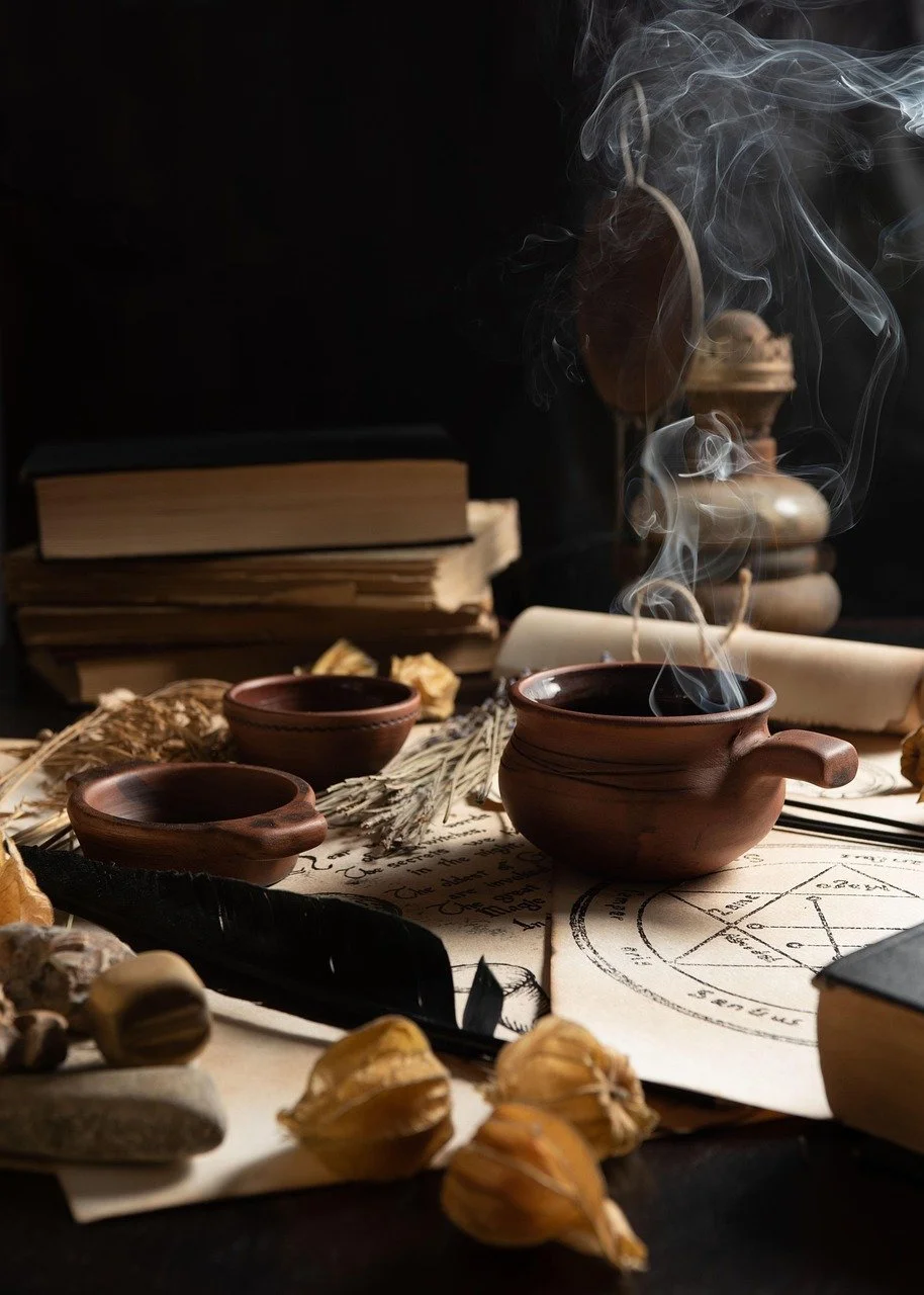 A mystical scene with steaming wooden bowls, old books, dried herbs, and occult symbols on paper, creating an atmosphere of magic and mystery.