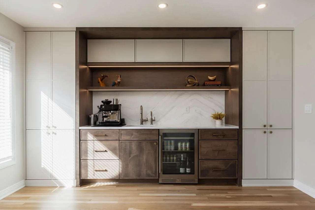 A custom coffee corner made for calmer mornings ☕️ 
Refinished hardwood floors throughout the home brightens up the Woodbridge project, while walnut inspired cabinetry carries warmth throughout the space. Brilliant brass pendants and skinny shaker ca