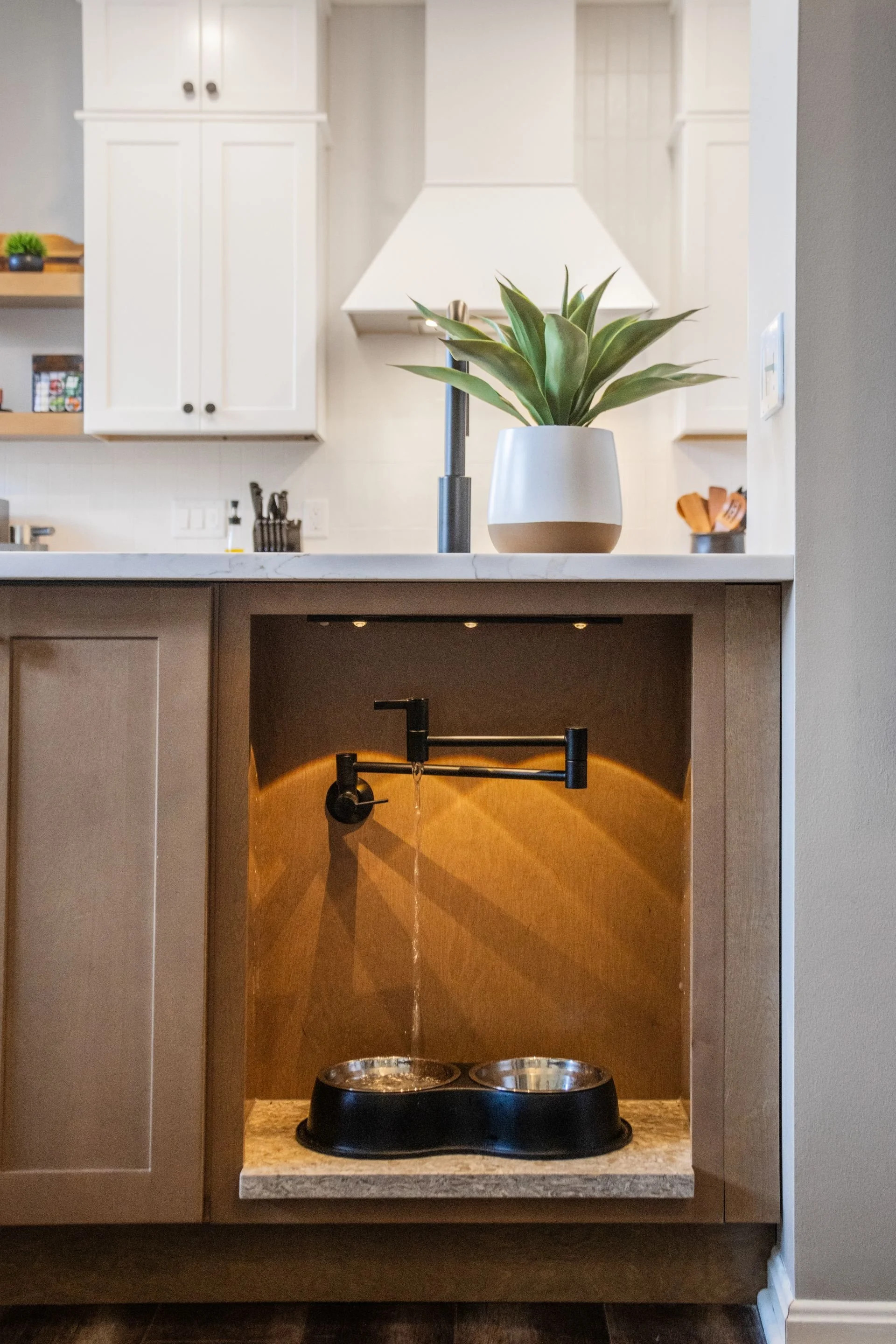 Custom kitchen cabinetry in Central Ohio home with built-in pet watering station and matte black pot filler by Residence.
