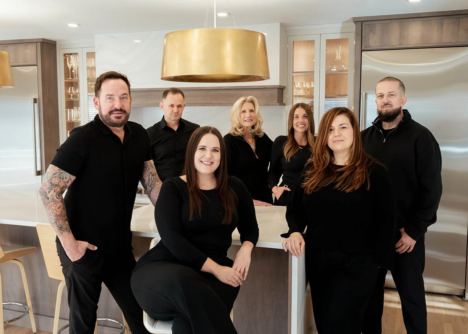 Residence design and remodeling team in Central Ohio standing together in a newly renovated kitchen.