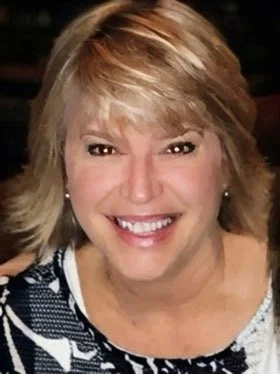 Close-up of smiling woman with blonde hair and earrings