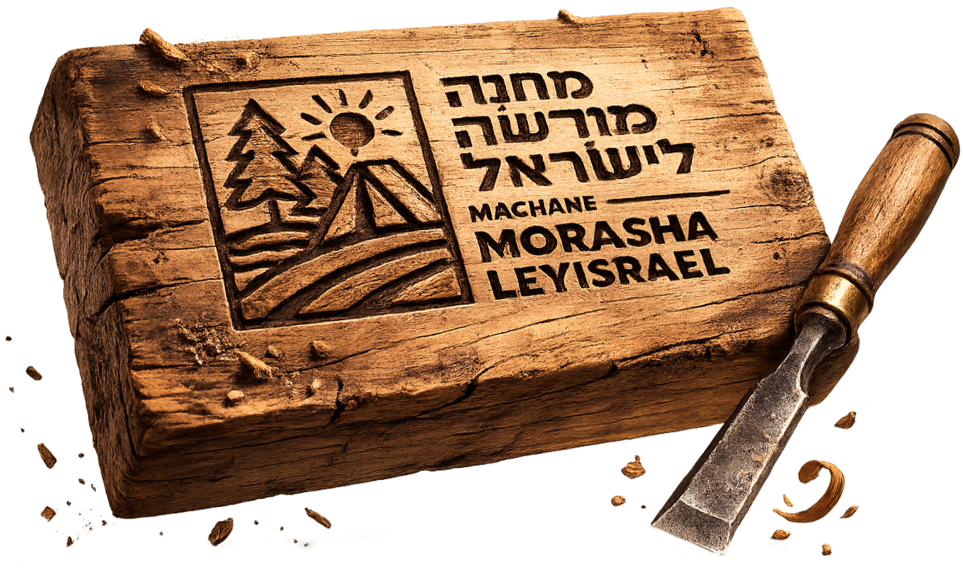 A wooden stamp with Hebrew and English text that reads "Machane Morasha Leyisrael" and features a carved image of a tent, trees, a sun, and mountains, with a carving tool next to it, surrounded by wood shavings.