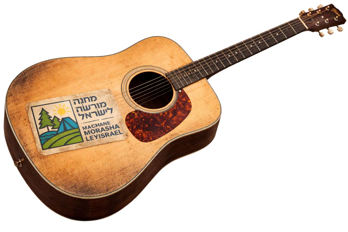 A wooden acoustic guitar with a sticker in Hebrew and English that reads 'Machane Morsha Leyisrael,' featuring mountains, trees, and a sun.