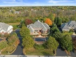 Aerial view of residential homes and wooded properties and roofs in Chenequa, Wisconsin