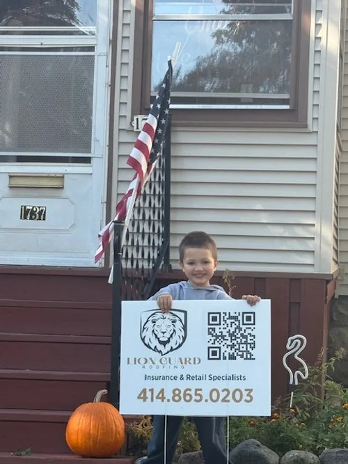 Scenic landscape of a lake surrounded by rolling hills and mountains under a cloudy sky.
