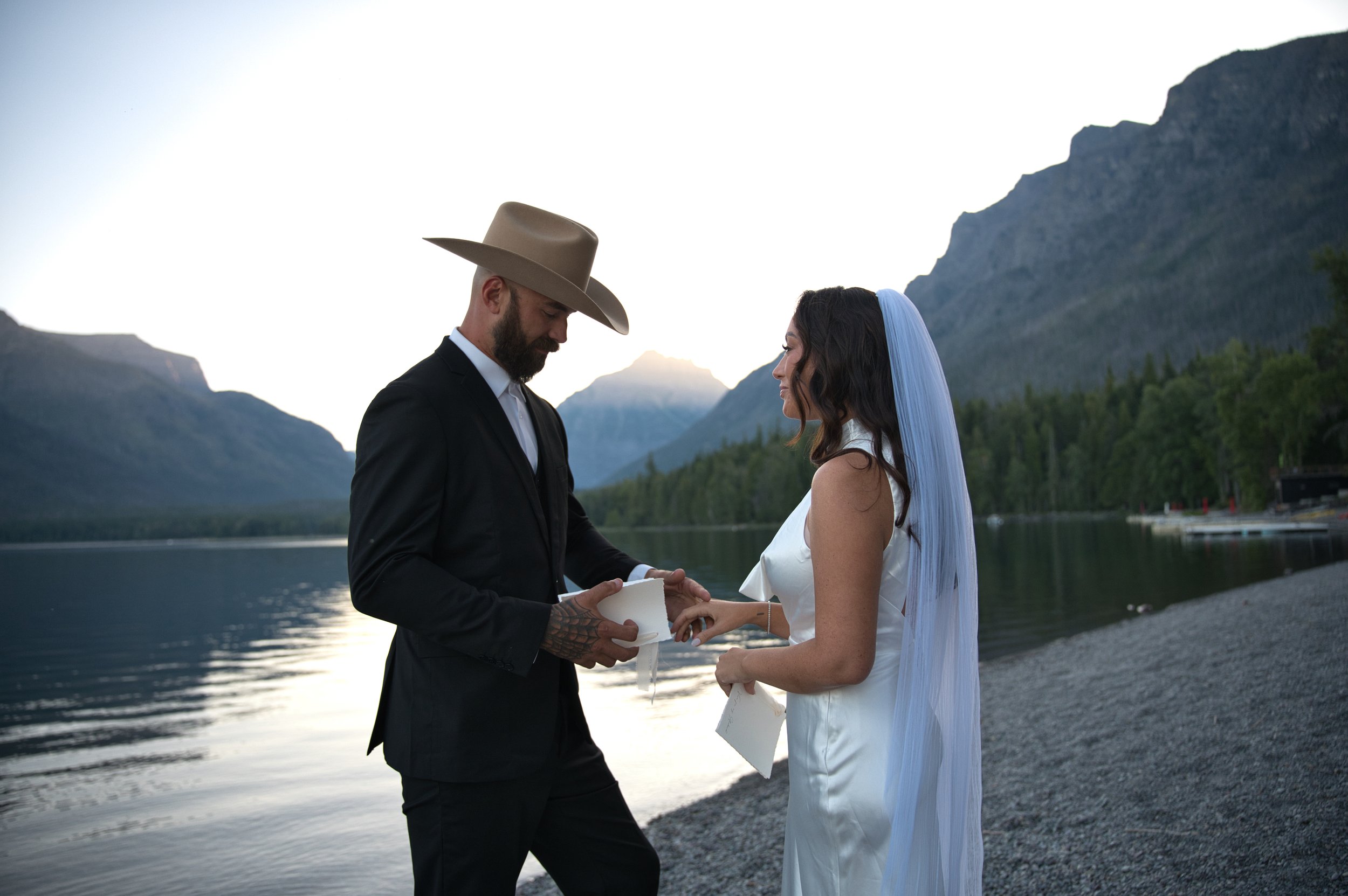 Couple reading vows during their Montana elopement at Lake McDonald in Glacier National Park.