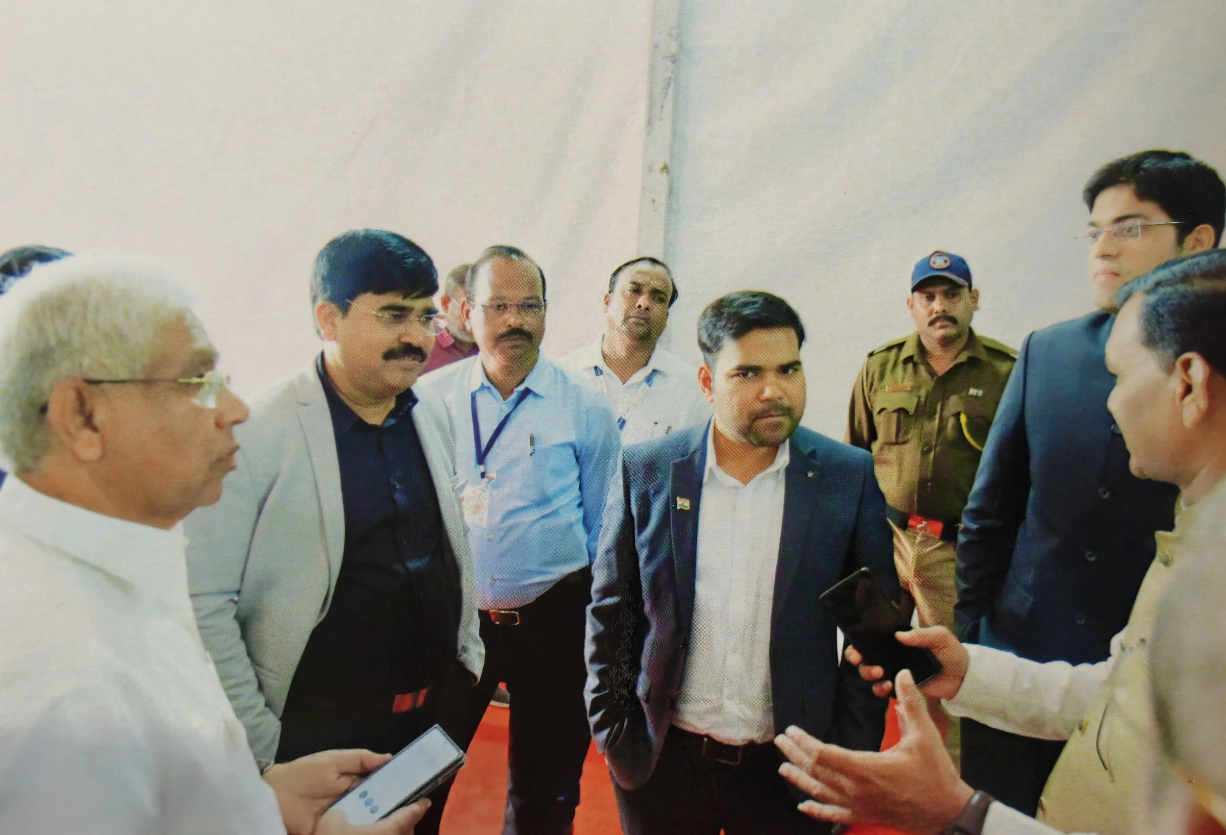 Group of men in formal and police uniforms having a discussion indoors.