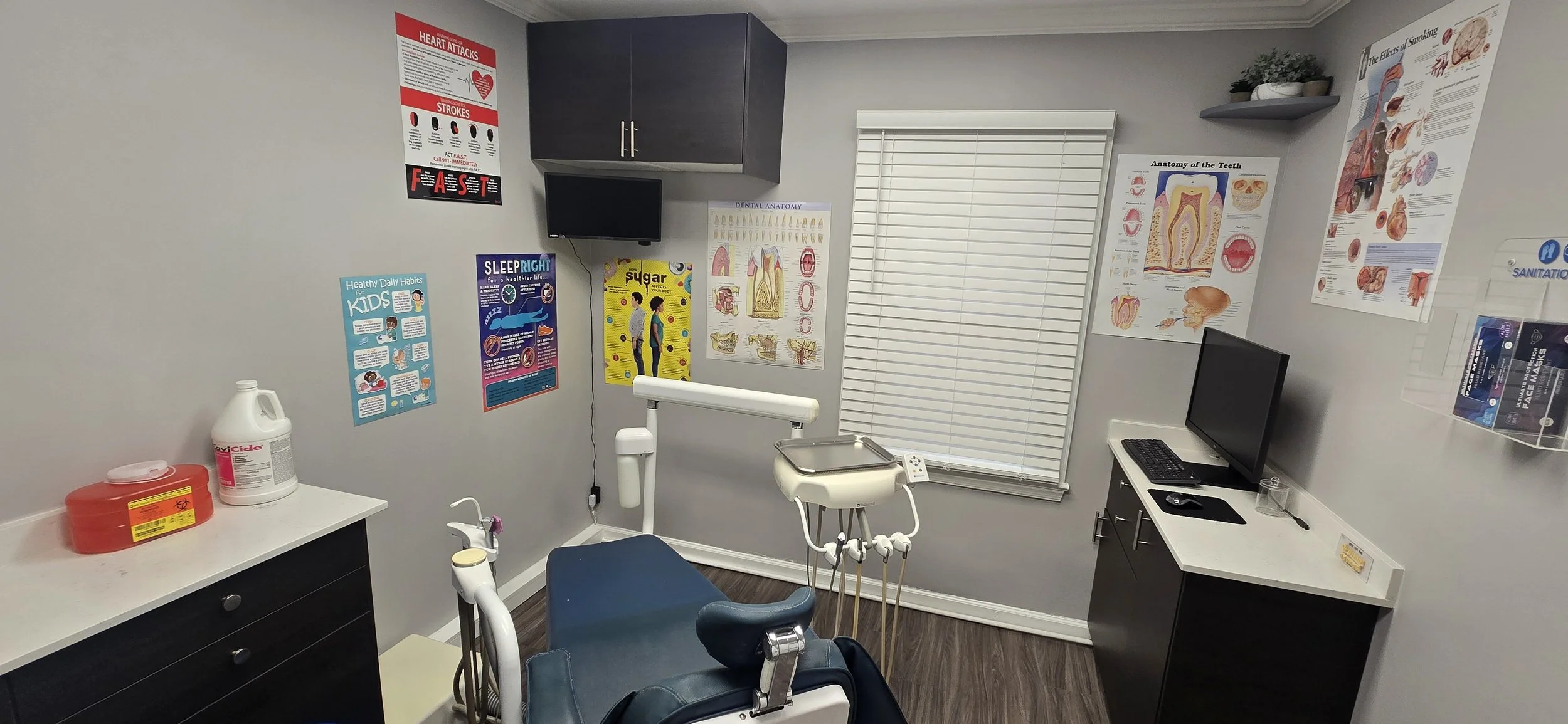 dentist exam room and dentist chair, inside dentist office.  The image has dental posters on the wall and dental equipment.
