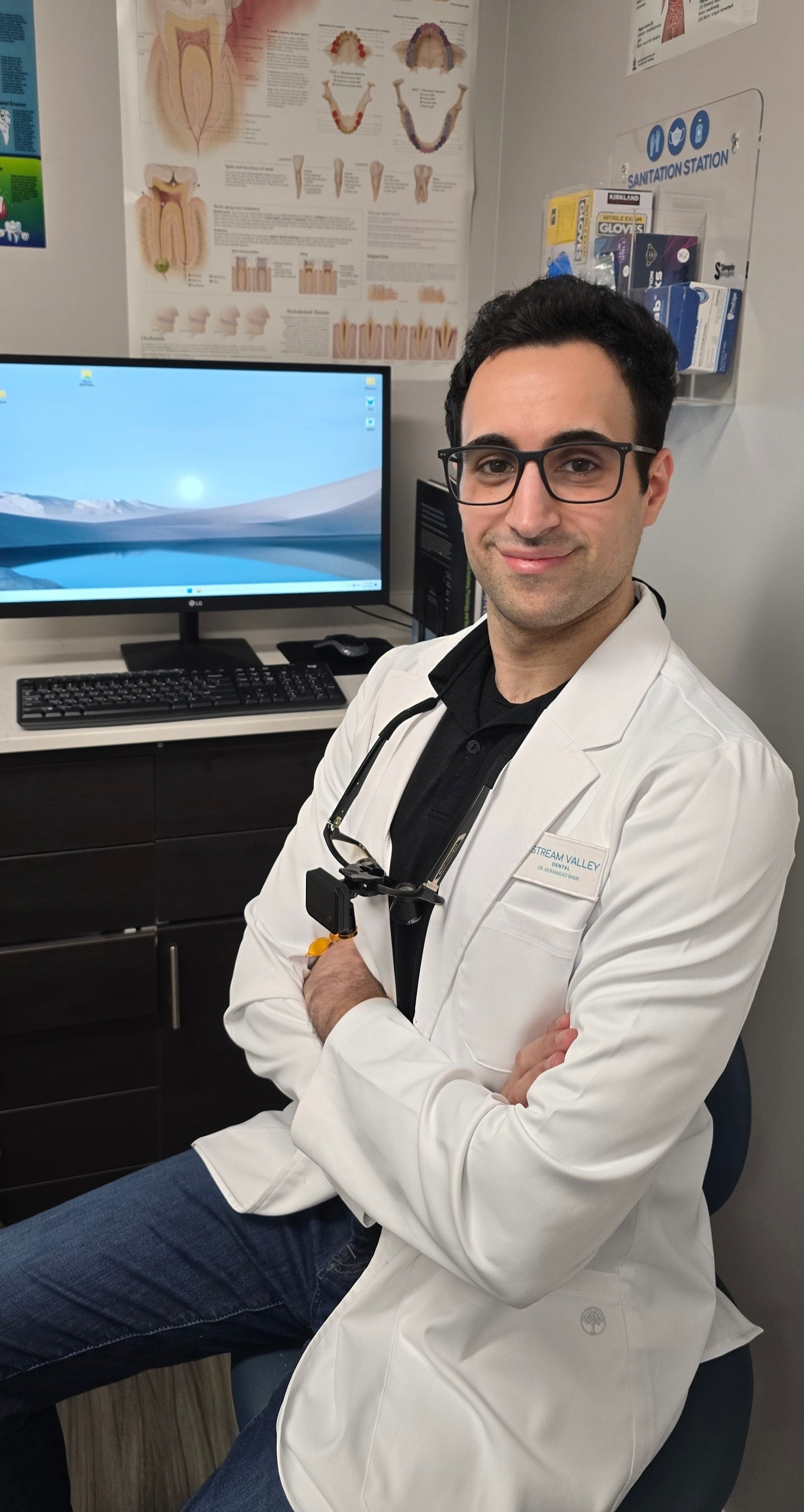 Dr. Bakir sitting in front of a computer at Stream Valley Dental