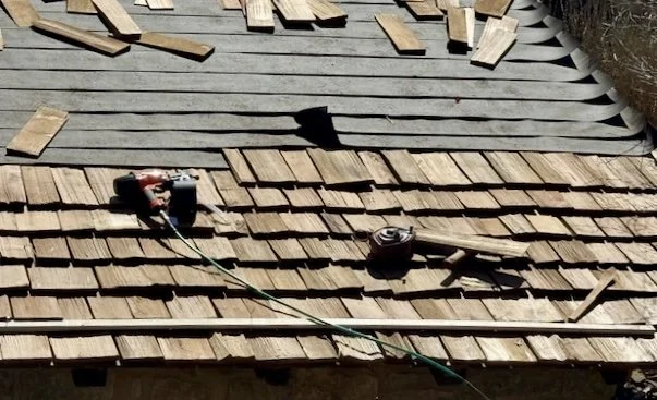 Roof with tools and wooden planks, indicating roof repair or construction.