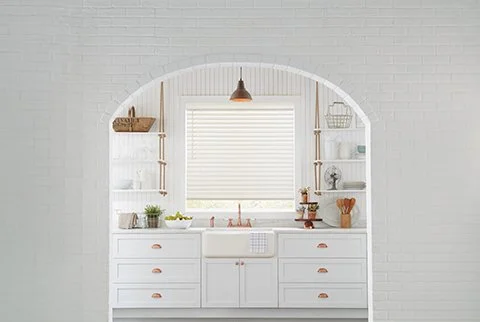 Custom kitchen interior design with integrated cabinetry, open shelving, and tailored window treatments, creating a bright, functional workspace as part of full-service interior design in Southwest Michigan.