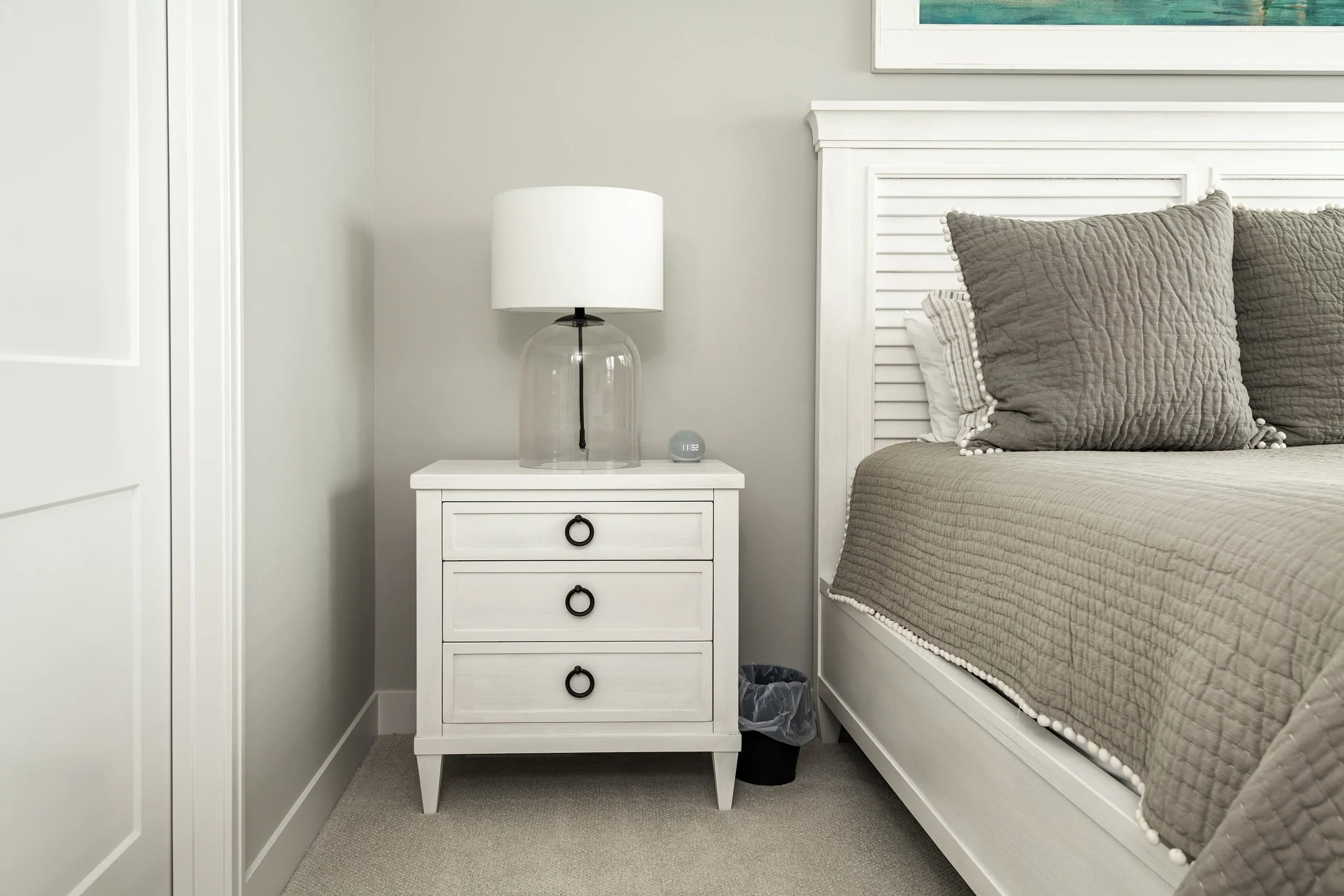 Bedroom detail featuring a custom nightstand, soft layered textiles, and simple accent lighting, adding warmth and function to a refined bedroom interior.