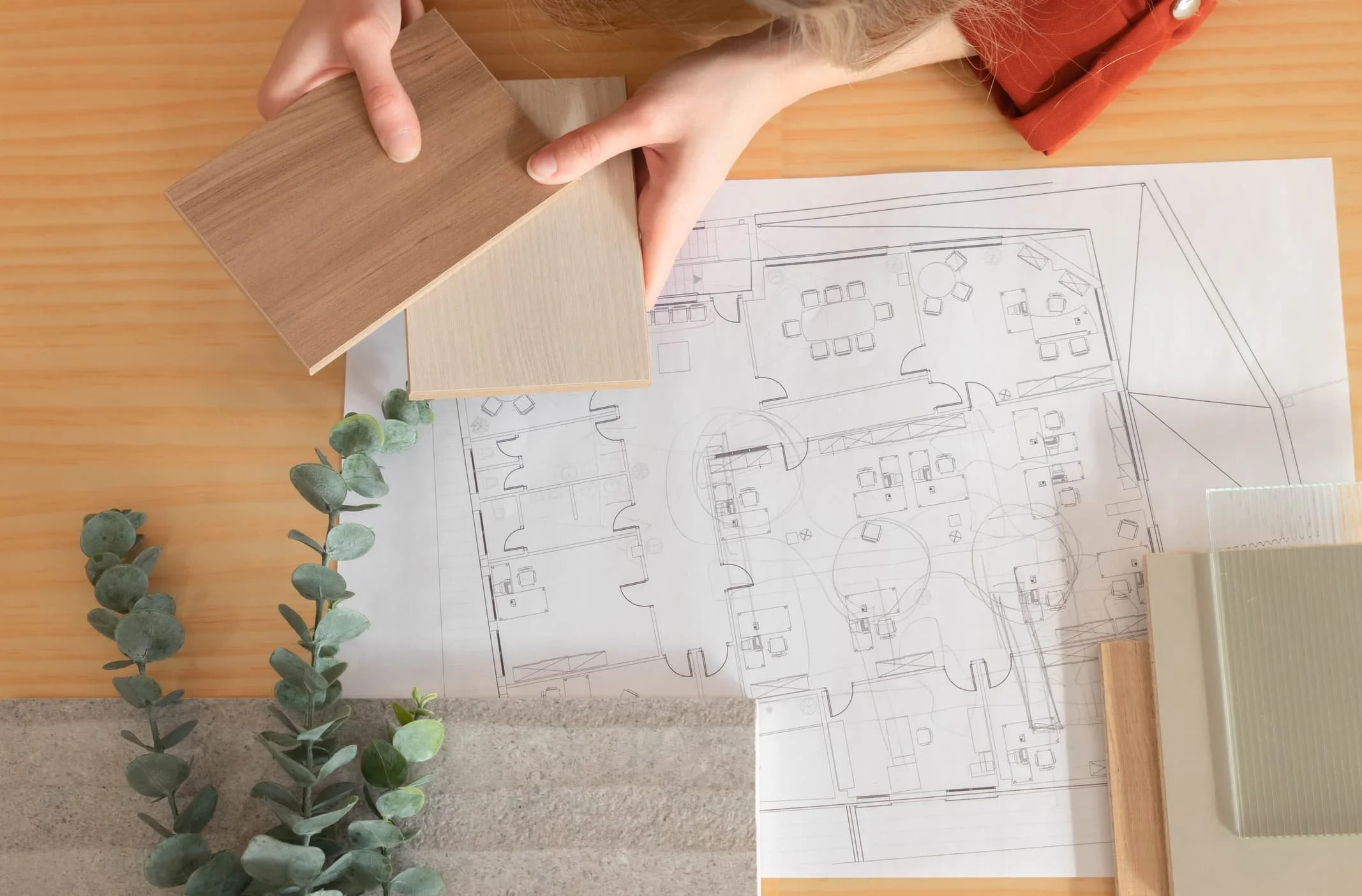 Two women smiling and looking at a brochure or magazine at a counter in a fabric or craft store.