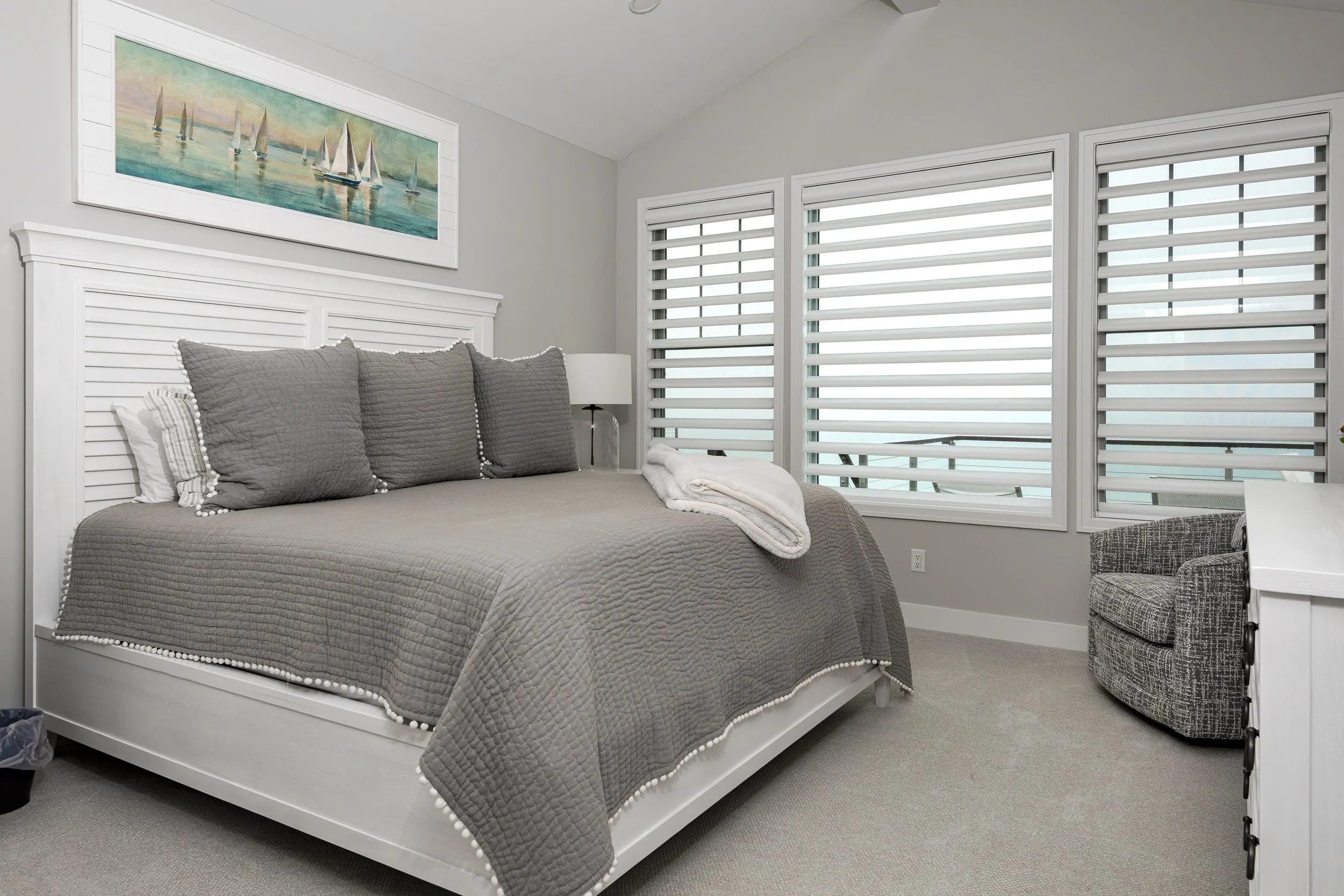 Bedroom interior design with custom bedding, soft neutral tones, and tailored window treatments, creating a calm, coastal-inspired retreat in a Southwest Michigan home.