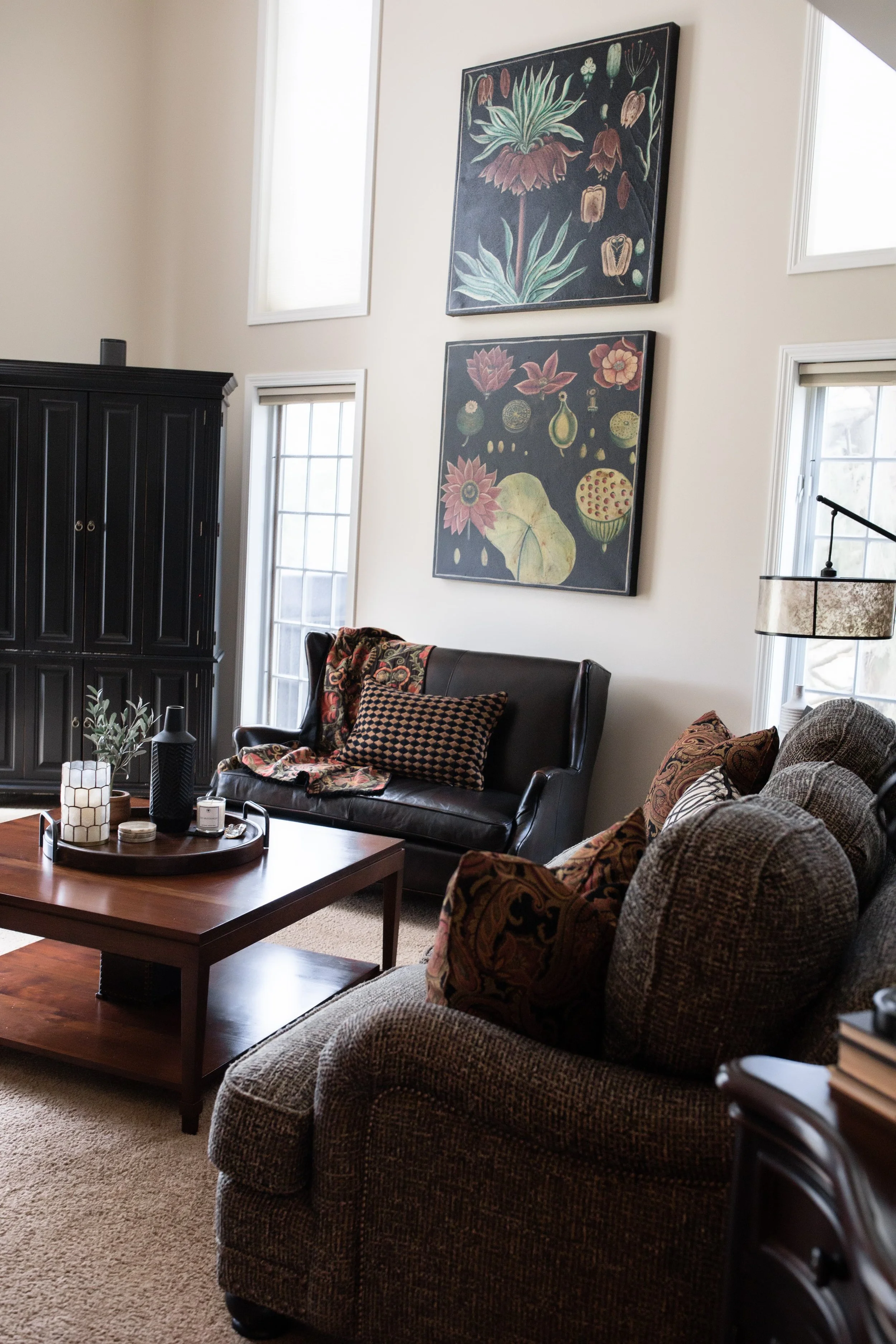 Living room interior design with warm wood furnishings, layered textiles, and curated artwork, creating a comfortable, lived-in gathering space in a Southwest Michigan home.