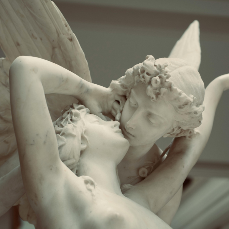 Close-up of a white marble sculpture depicting two intertwined lovers in an intimate pose.