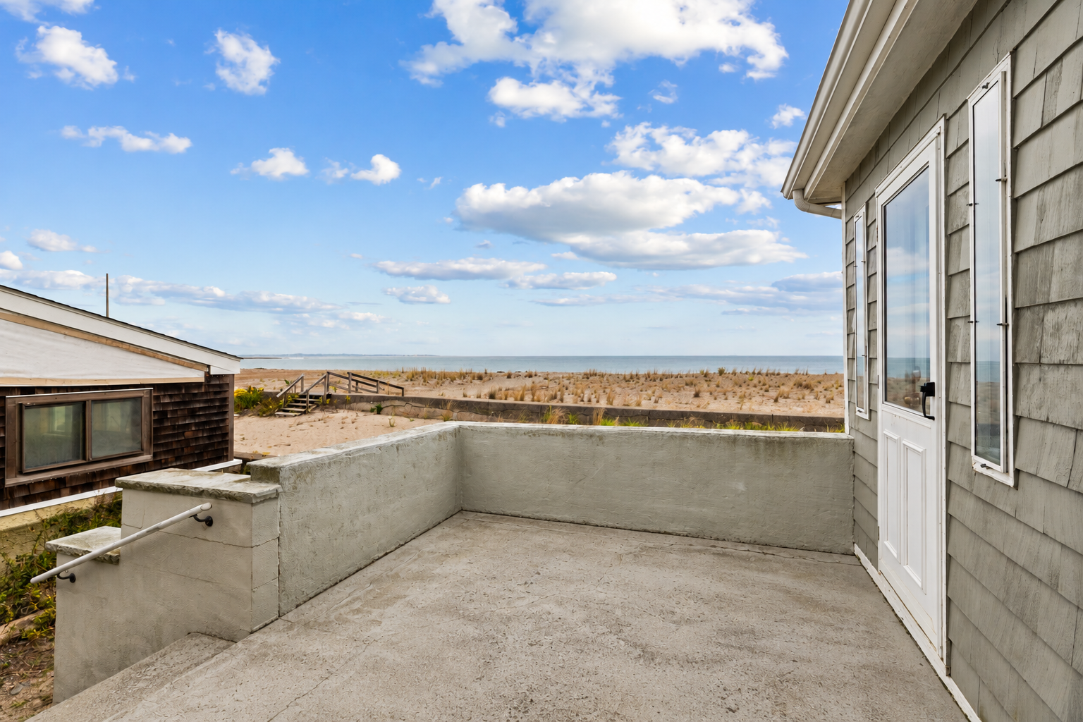 Empty Coastal Patio Overlooking Dunes and Ocean.png