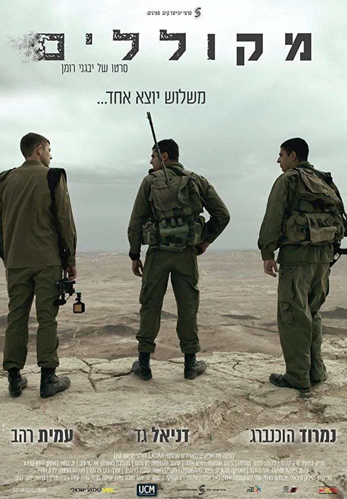Three soldiers in military gear standing and looking into a barren landscape with a cloudy sky.